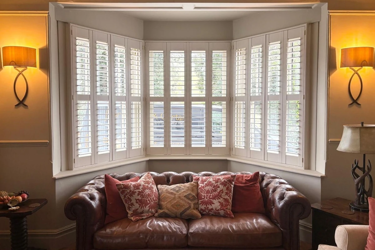 White plantation shutters fitted to a large bay window